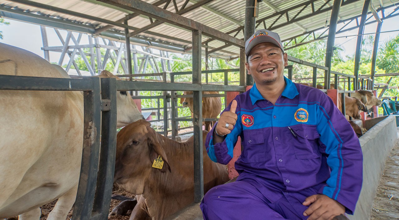 Syahrian the head of P4S—Karya Baru Mandiri next to his cow shed